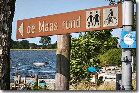 Wandern in Maasholm: Der Rundweg de Maas rund Braunes Holzschild mit der Aufschrift