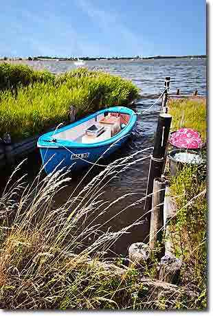 Fischerboot in Maasholm an der Schlei Ein kleines blaues Fischerboot mit der Kennung MAA 30 liegt an einem Holzsteg im schilfumringten Wormshöfter Noor in Maasholm an der Schlei.